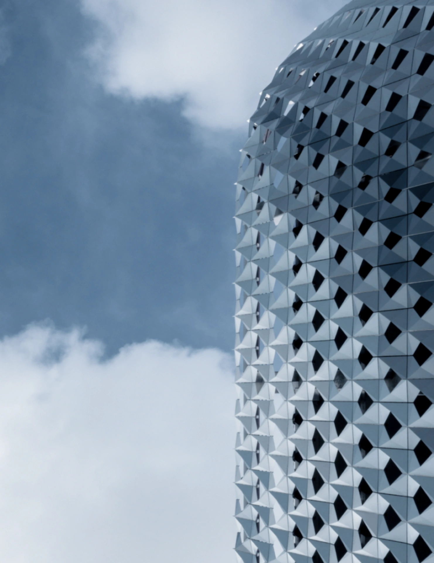 Striking architectural design of the high-rise building featuring sleek glass façade, curved lines, and modern luxury style.