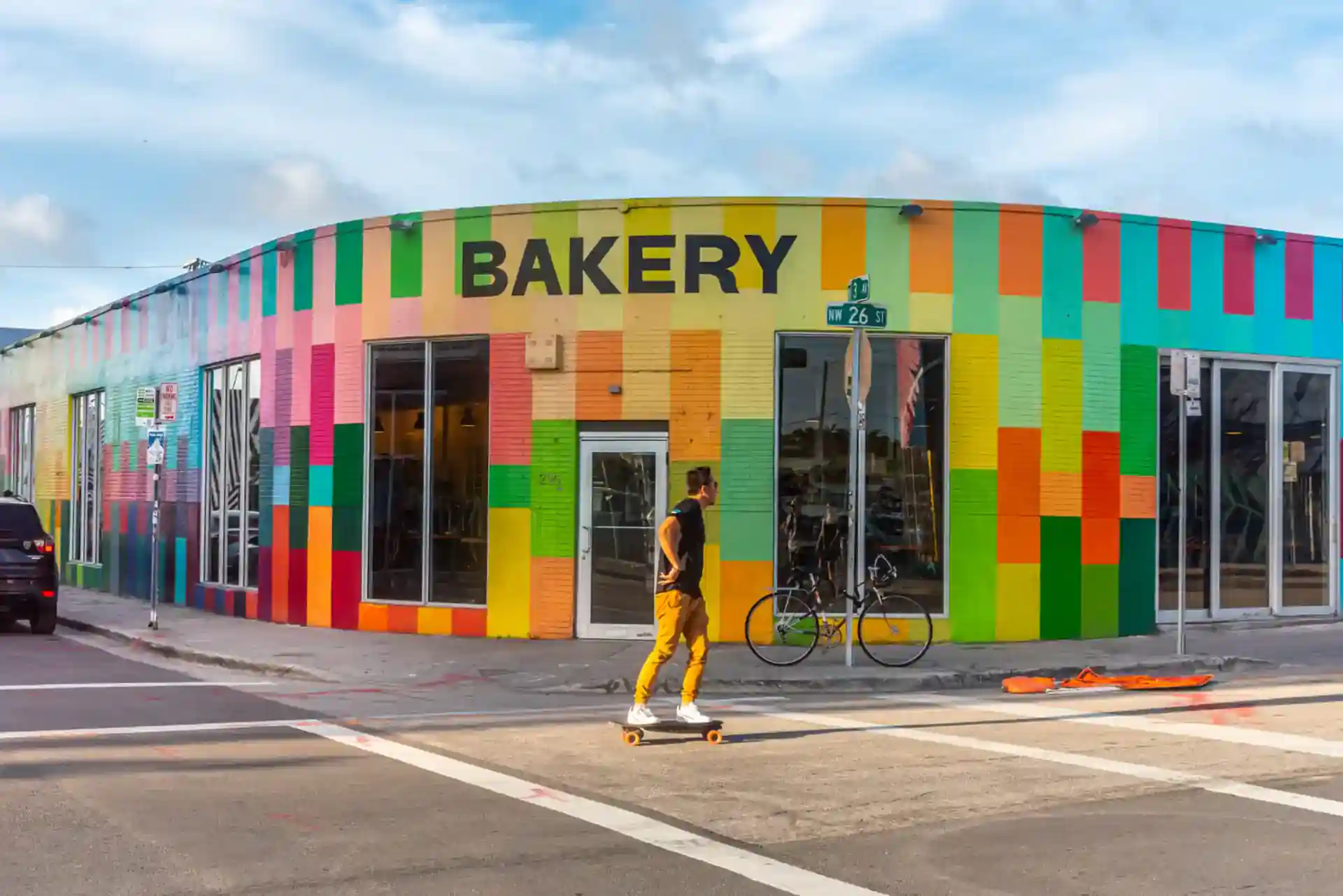 The exterior entrance of the bakery is painted with a vibrant array of colors, adding a lively and eye-catching touch.